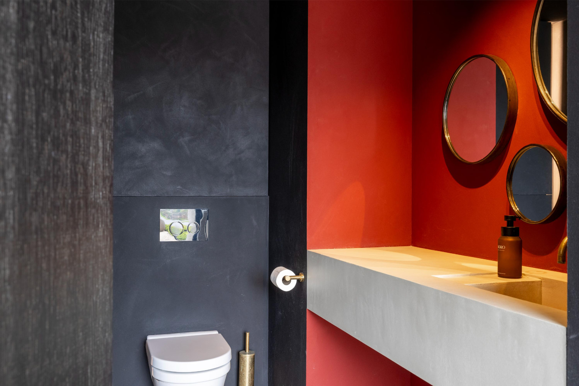 Toilet met rode nis en messing spiegels